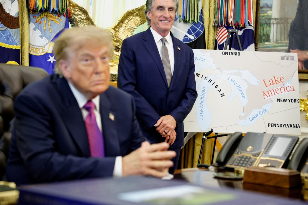 O presidente dos EUA, Donald Trump, fala à imprensa à frente de mapa indicando a mudança de nome do lago Ontário para lago América, em 27 de agosto de 2026. — Foto: Evan Vucci/ Reuters