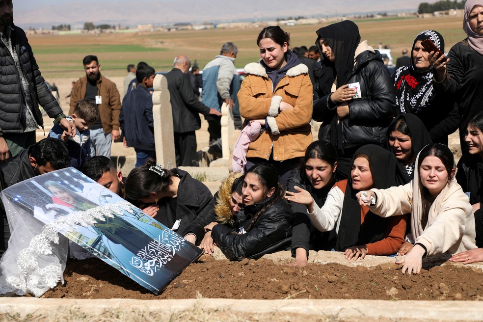 Grupo se reúne durante funeral de vítima após centenas de mortes na Síria — Foto: Reuters/Orhan Qereman