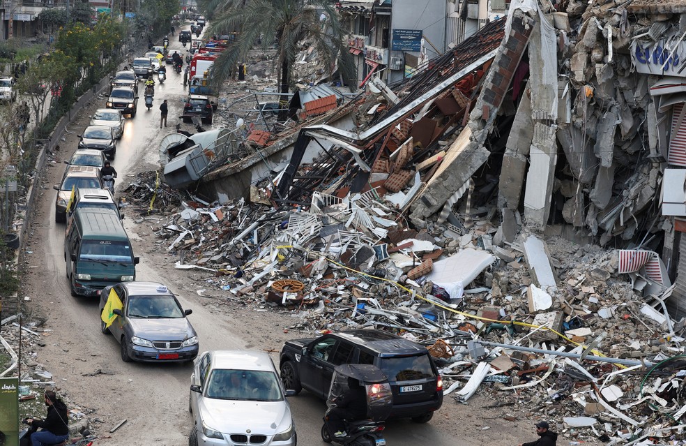 Veículos circulam perto de prédios danificados nos subúrbios do Sul de Beirute — Foto: Adnan Abidi/Reuters