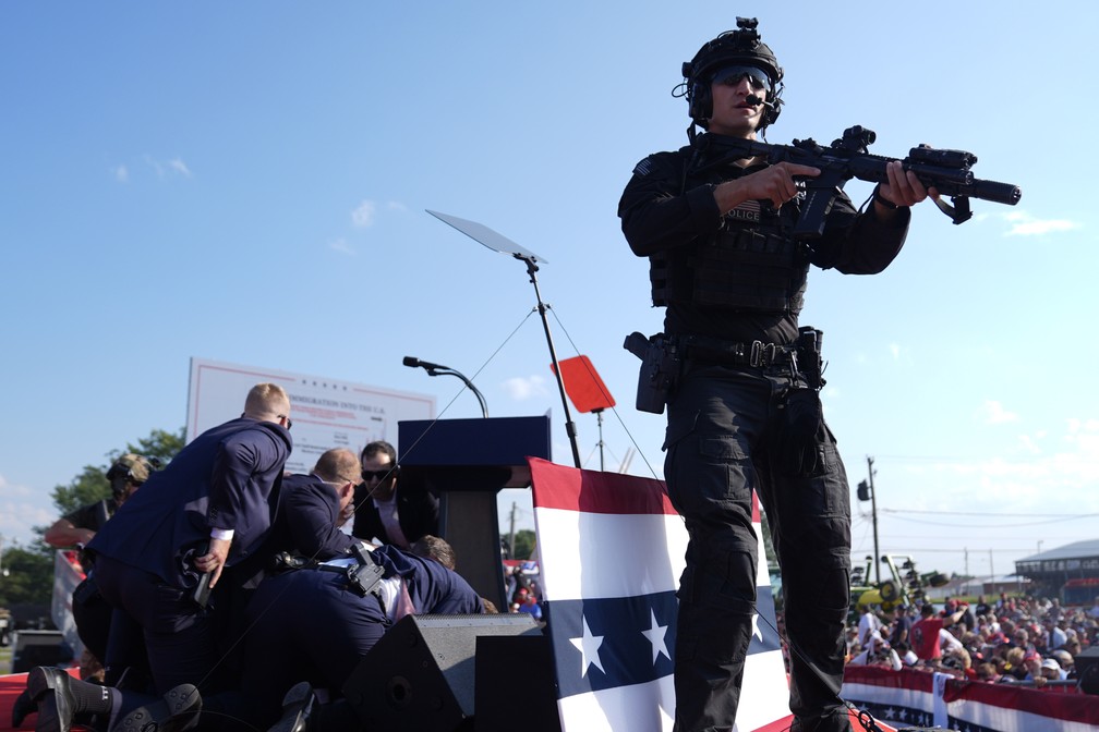 Donald Trump recebe o apoio de agentes do Serviço Secreto após tiros em comício — Foto: AP Photo/Evan Vucci