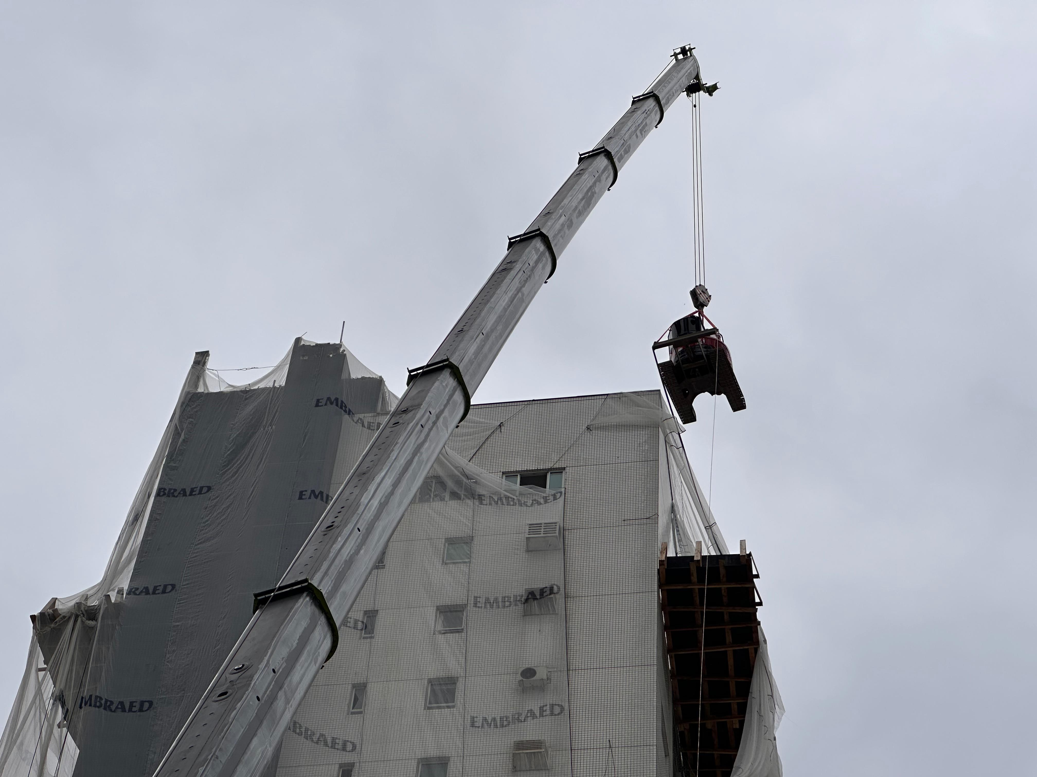 Escavadeiras de 11 toneladas são içadas ao topo de edifício de 20 andares para iniciar demolição da estrutura em SC; VÍDEO