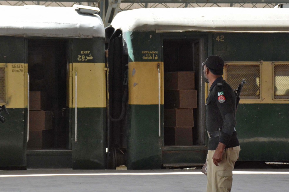 Segurança faz guarda de trem contendo caixões vazios que foram enviados para Bolan, onde um trem de passageiros foi atacado por grupo separatista no Paquistão em 12 de março de 2025. — Foto: REUTERS/Stringer