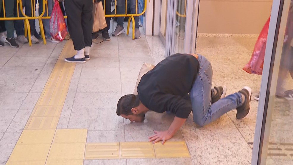 Brasileiro repatriado desembarcou em Confins e beijou o chão. — Foto: Henrique Campos/TV Globo