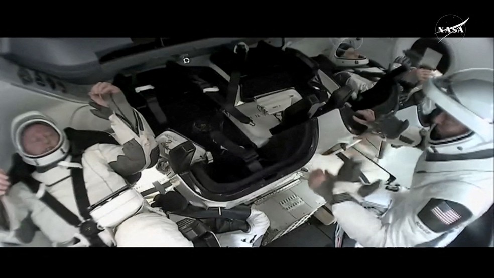 Imagem dos astronautas dentro da cápsula — Foto: Reuters