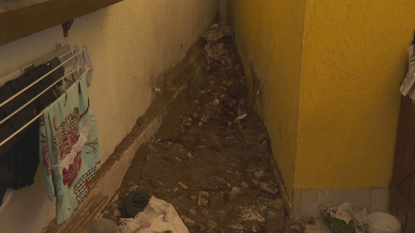 Corpo estava enterrado dentro de casa no bairro Ouro Preto, na Pampulha — Foto: Jussara Ramos/TV Globo