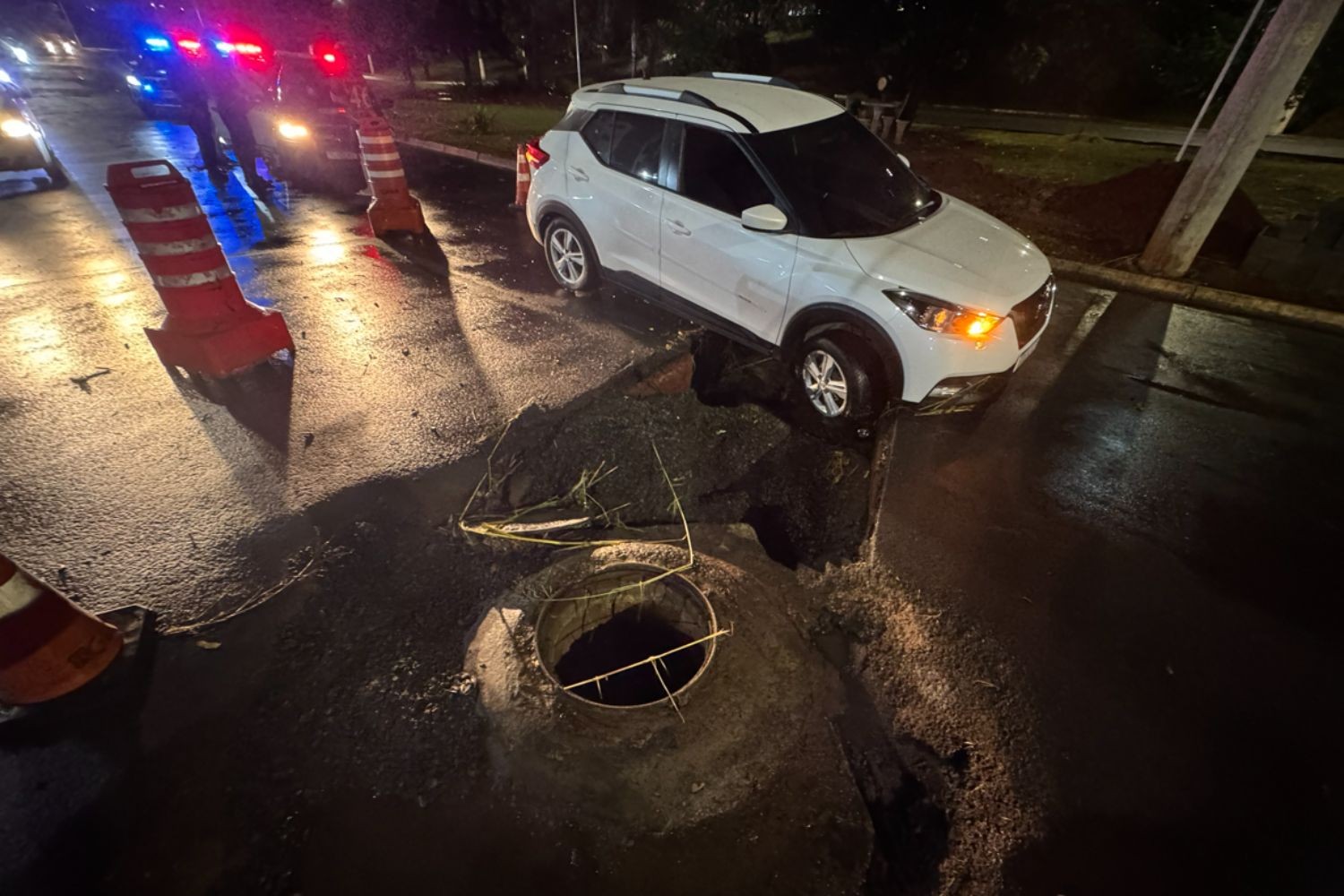 Carro fica preso em cratera após chuva em avenida de Americana; VÍDEO