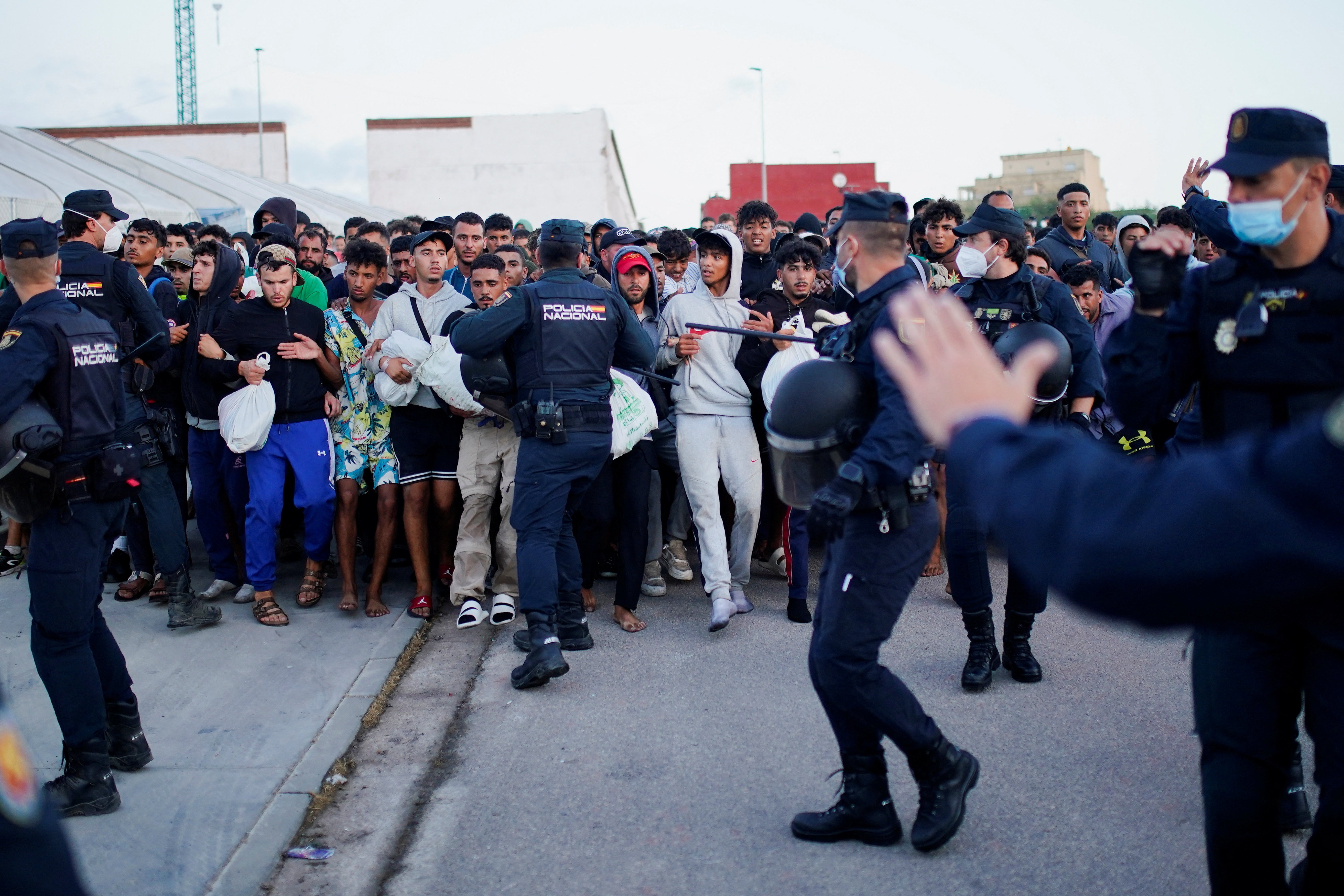 Em Ceuta, polícia espanhola transfere migrantes de praias para alojamento temporário no porto