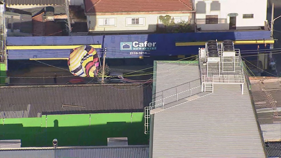 Balão fica enroscado no telhado de supermercado na Vila dos Bancários. — Foto: Reprodução/TV Globo