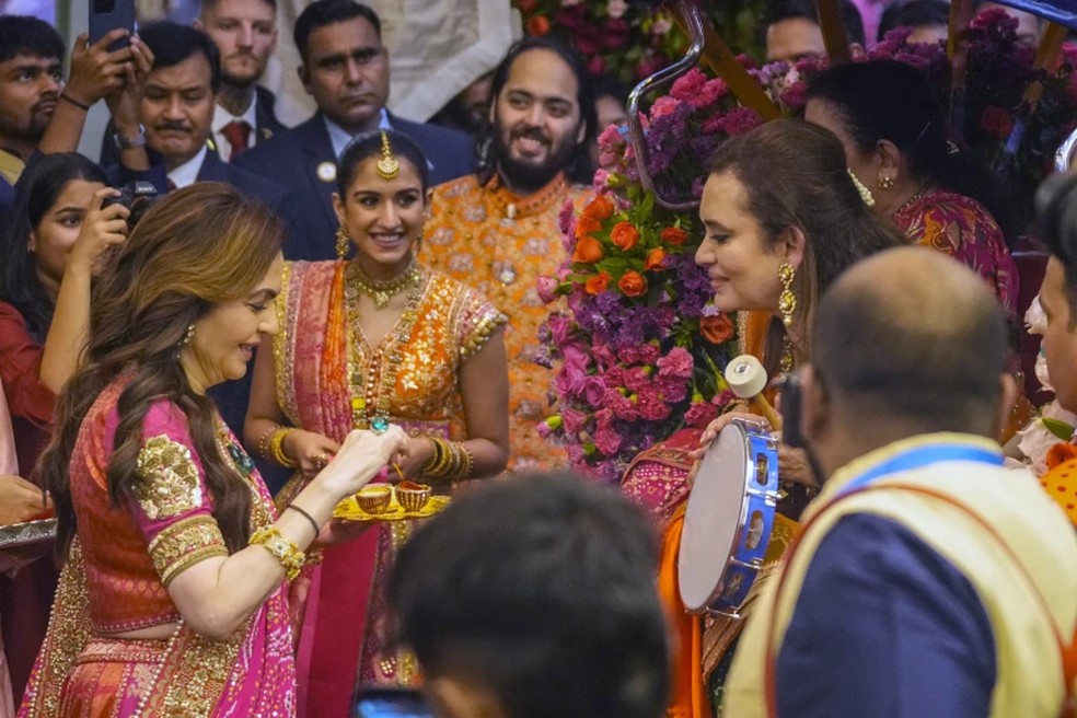 Nita Ambani, à esquerda, esposa de Mukesh Ambani, junto com seu filho Anant Ambani, ao centro à direita, e sua noiva Radhika Merchant, segunda à esquerda, cumprimentam os convidados durante a cerimônia pré-casamento em sua residência em Mumbai, Índia, quarta-feira, 3 de julho de 2024. — Foto: AP Photo/Rafiq Maqbool, arquivo