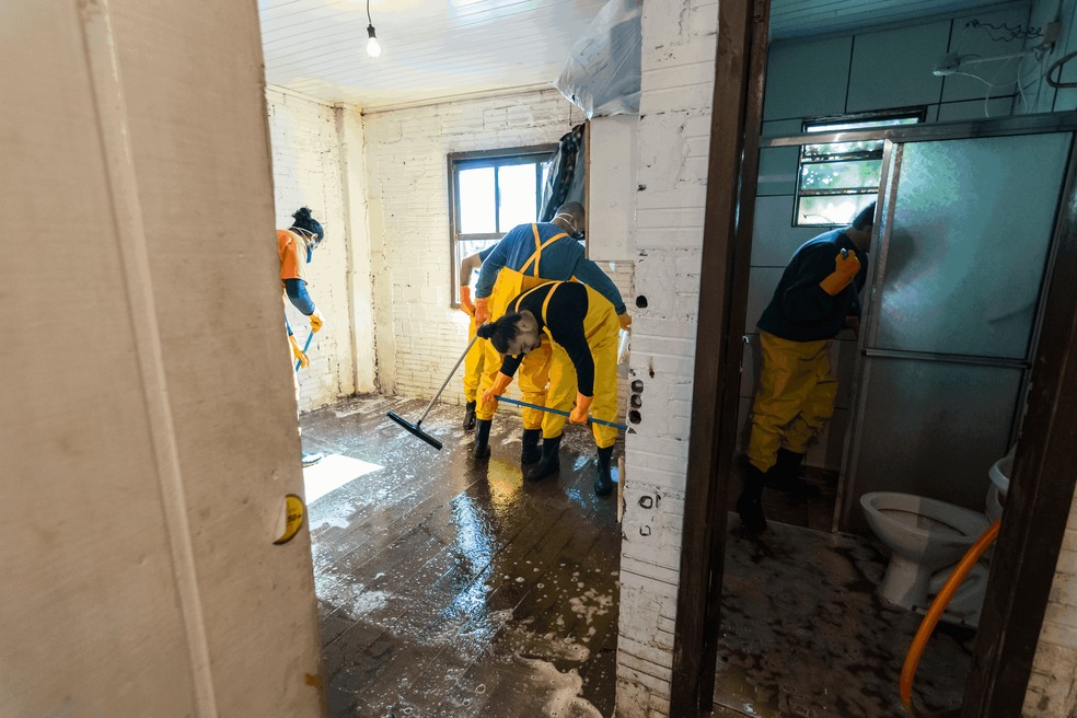 Voluntários limpam casa tomada pela lama após a água do Rio Taquari baixar. — Foto: Gentilly Costa/Divulgação