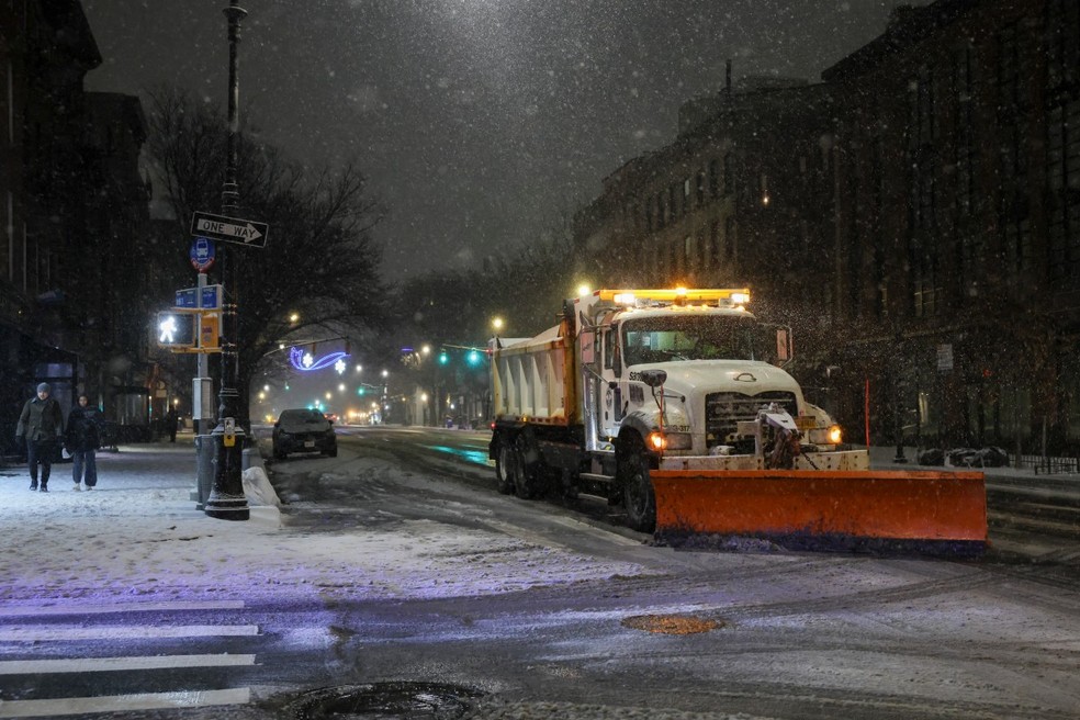 Veículos de limpar neve circulam por Nova York na noite de 26 de dezembro de 2025 — Foto: AFP
