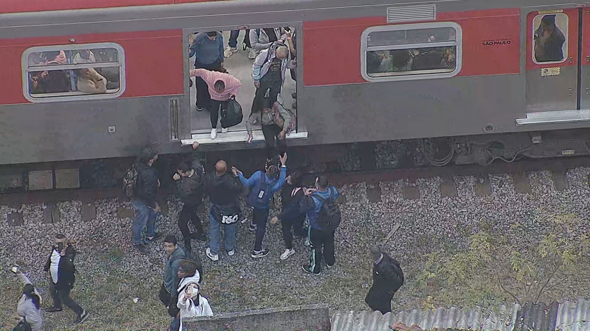 Passageiros caminham pelos trilhos após trem apresentar falha na linha 12-Safira da CPTM