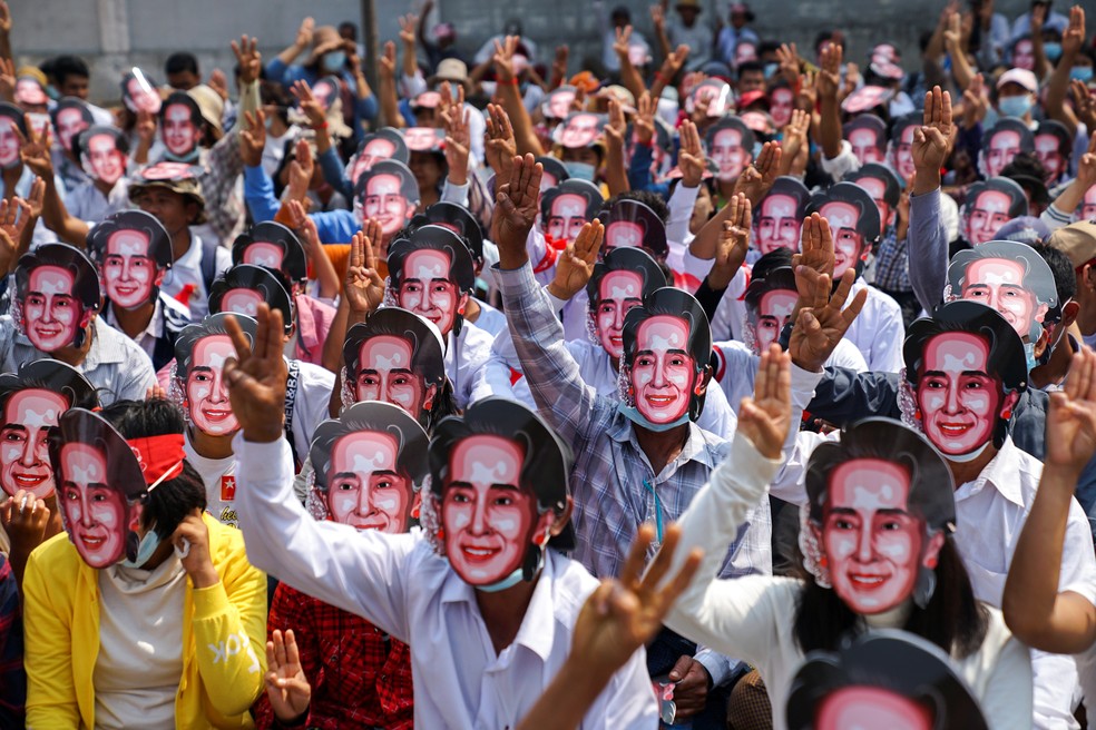 Manifestantes usando m&aacute;scaras com o rosto de Aung San Suu Kyi protestam na cidade de Yangon, em Mianmar, neste domingo (28) &mdash; Foto: Stringer/Reuters