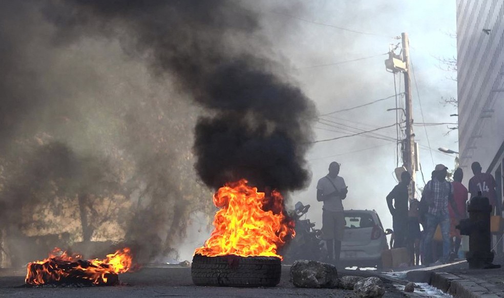Pneus em chamas bloqueiam via em Porto Príncipe, no Haiti, após ataque a prisão que liberou milhares de detentos — Foto: Luckenson Jean/AFPTV/AFP