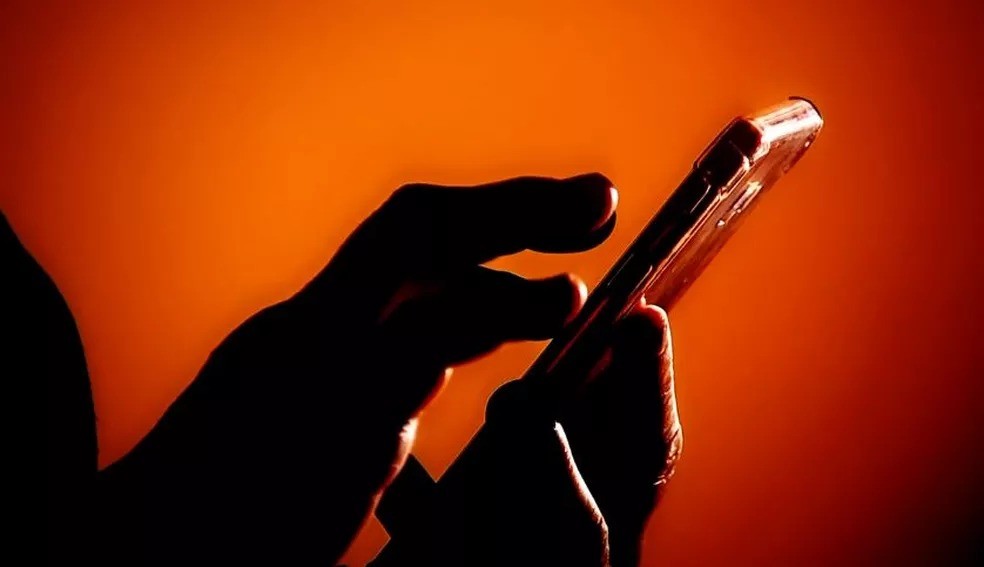 Pessoa usa celular, meio usado por golpistas para praticar crimes — Foto: Reprodução/TV Globo