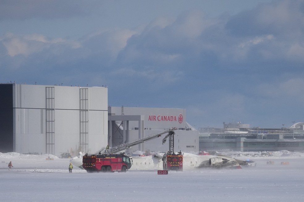 Avião da Delta é visto de ponta-cabeça em pista do aeroporto Toronto Pearson, no Canadá — Foto: Arlyn McAdorey/Reuters