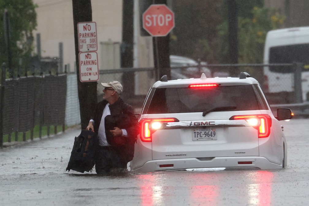 Homem caminha em rua de Nova York com água até depois dos joelhos durante uma tempestade imprevista e fora de época na cidade, em 29 de setembro de 2023. — Foto: Mike Segar/ Reuters