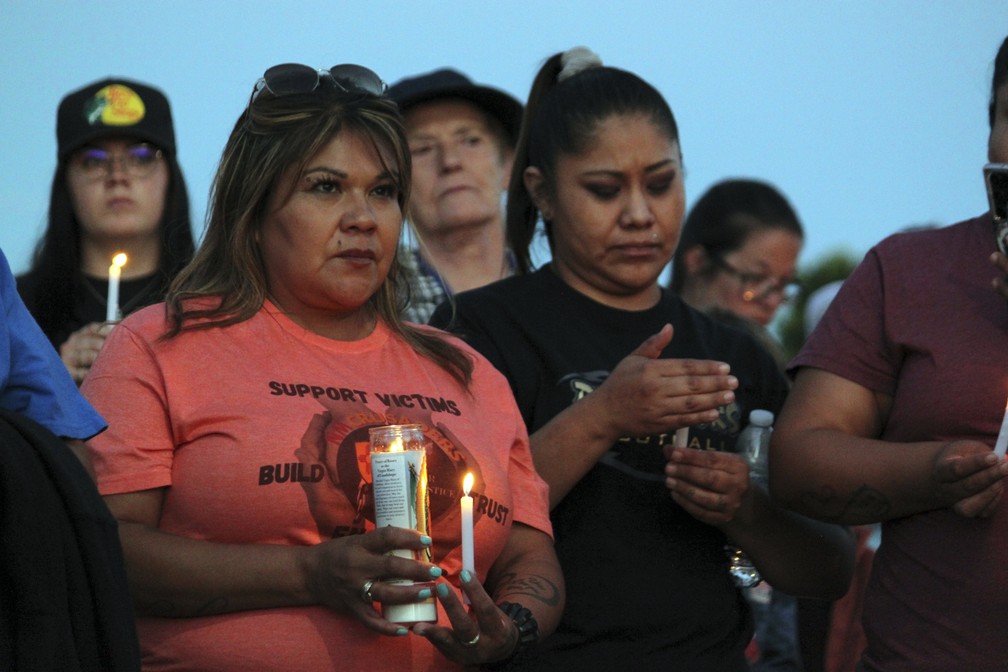 Membros da comunidade de Farmington acendem velas em homenagem aos que foram mortos durante ataque a tiros — Foto: Susan Montoya Bryan/AP