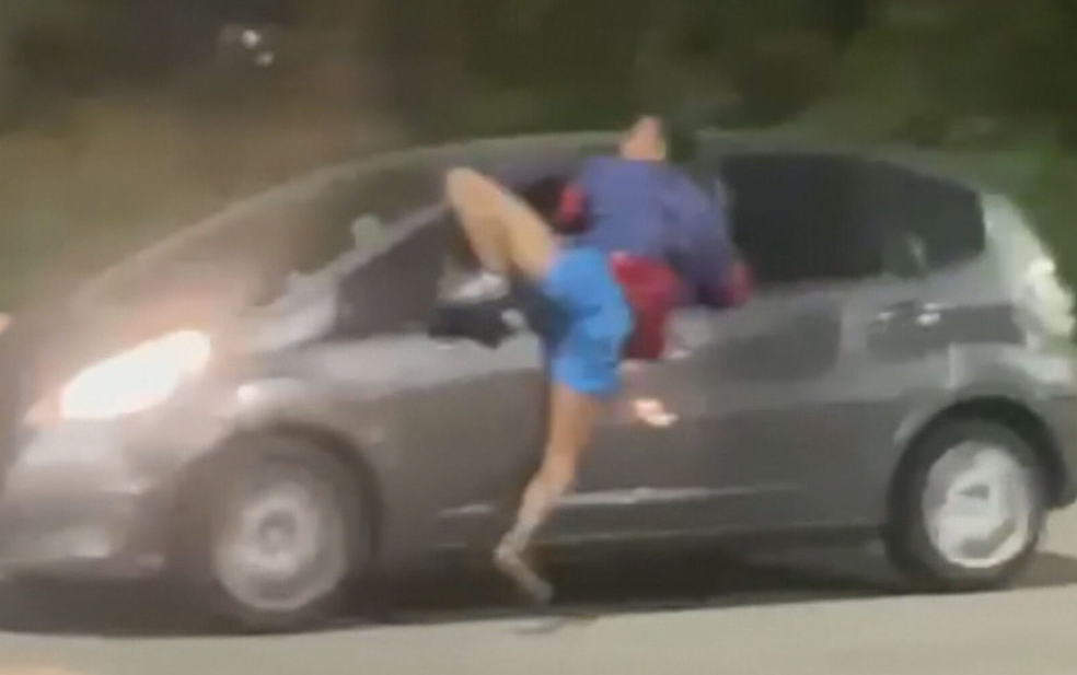 Homem ficou pendurado em janela de carro em movimento na Avenida Salvador Allende, na Zona Oeste do Rio — Foto: Reprodução/ TV Globo