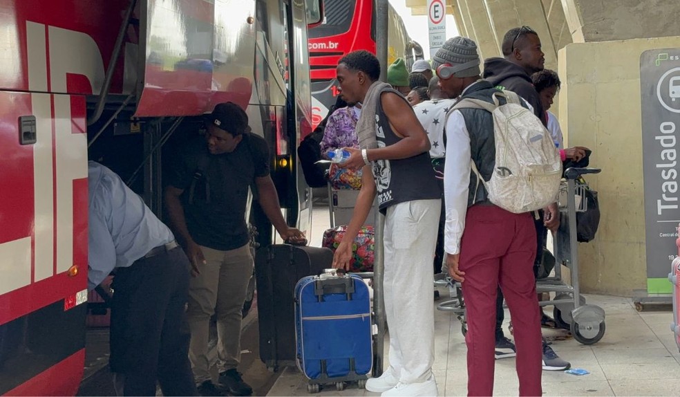 Morando há seis anos no Brasil, Marcos Carel ajuda outros haitianos na chegada ao Brasil por conta da barreira da língua, ajudando na compra de passagens rodoviárias de Viracopos para o Terminal do Tietê, em São Paulo (SP) — Foto: Estevão Mamédio/g1