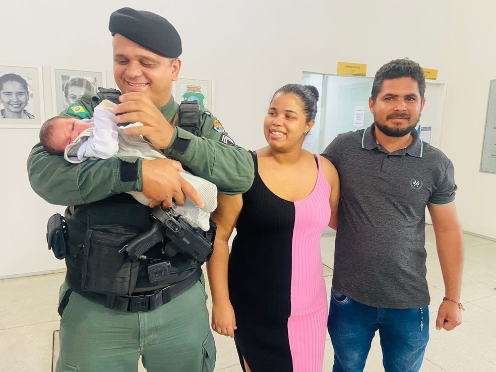 Sargento Kássio Sousa, que realizou a manobra que salvou Gael, ao lado dos pais do menino — Foto: Lorena Tavares/TVM