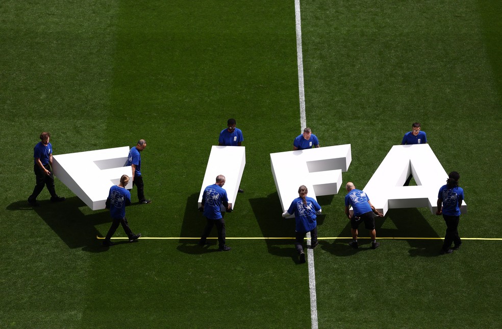 Integrantes da equipe de apoio carregam letras que formam a palavra "FIFA" antes da partida entre Bélgica e Senegal, pela Copa do Mundo de 2026, no Seattle Stadium, em Seattle (EUA). — Foto: REUTERS/Lee Smith.