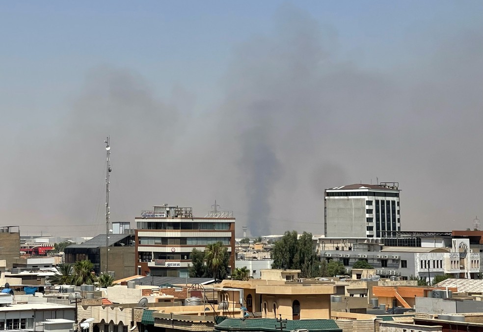 Fumaça preta sobe após explosões perto de uma base militar que abriga forças americanas na cidade de Irbil, no norte do Iraque — Foto: AP/Stella Martany