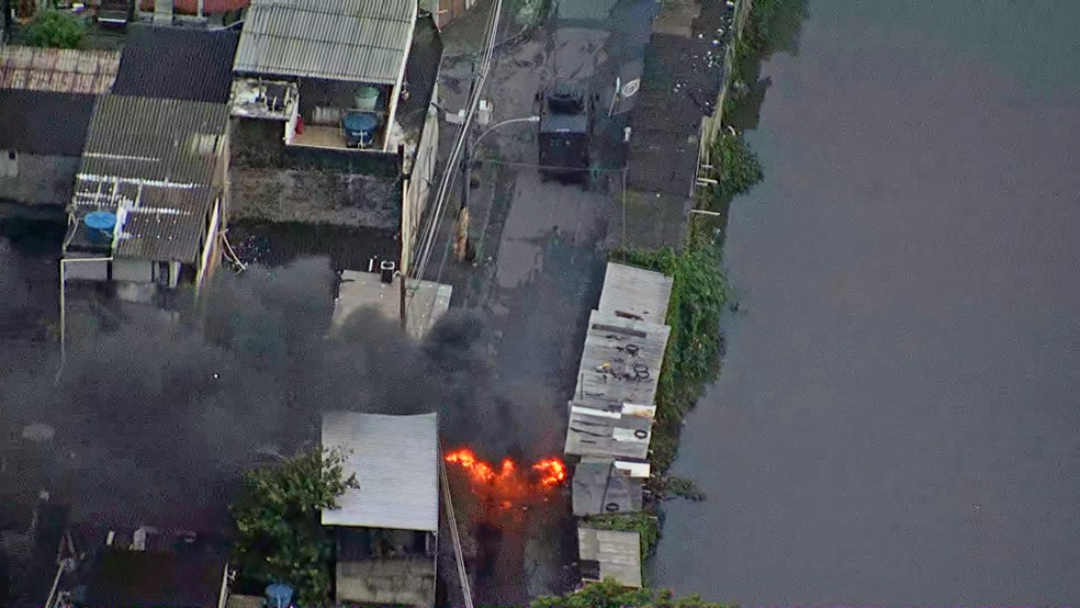 Blindado da PM diante de uma barricada em chamas na Cidade de Deus — Foto: Reprodução/TV Globo