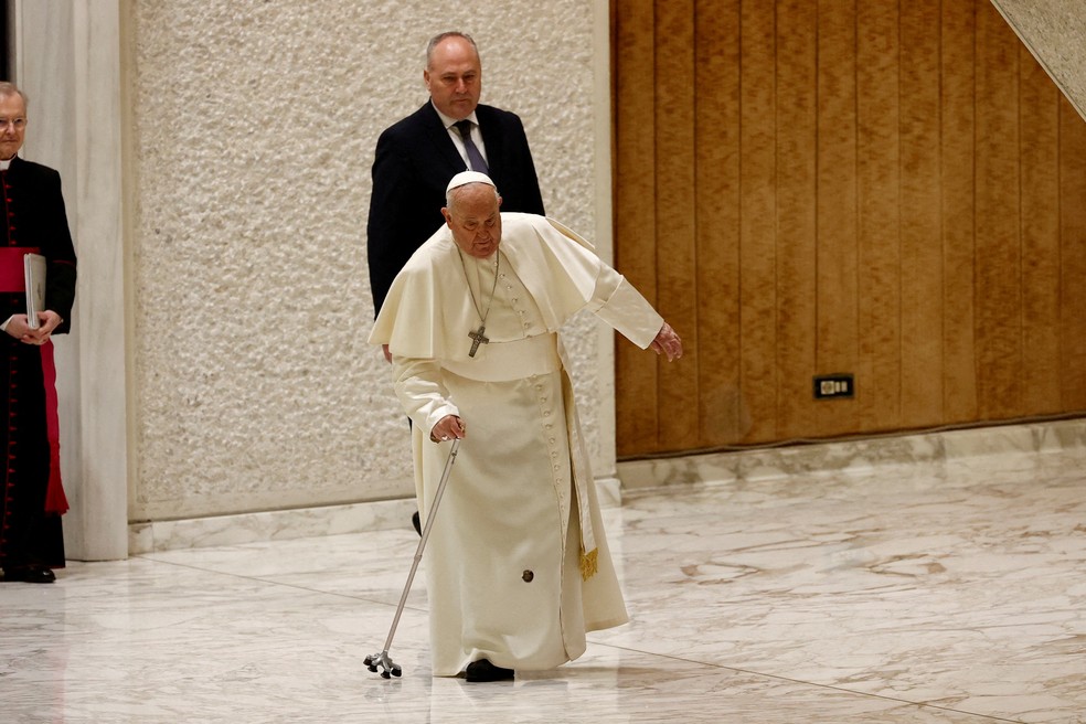 Papa Francisco tropeça quando parte de sua bengala se quebra, ao chegar para realizar a audiência do Jubileu na sala Paulo VI no Vaticano. — Foto: REUTERS/Ciro De Luca TPX IMAGES OF THE DAY