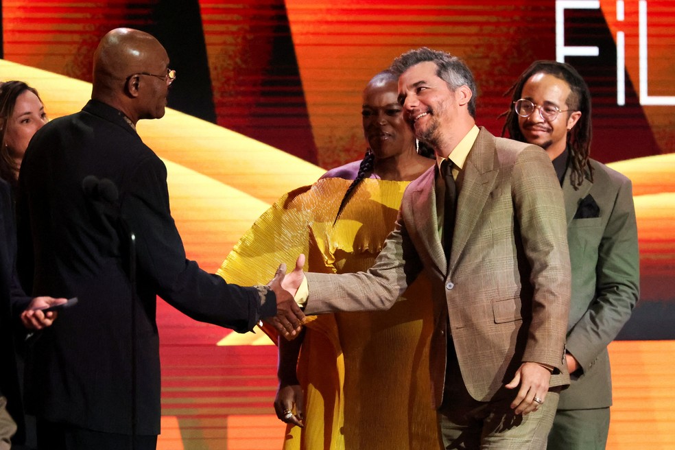 Delroy Lindo cumprimeta Wagner Moura no palco, após anunciar o prêmio de melhor filme internacional para "O Agente Secreto" durante cerimônia do Spirit Awards. — Foto: Mario Anzuoni/Reuters