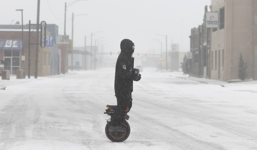 Homem anda em monociclo em Wichita, Kansas, durante a tempestade de neve no domingo (05) — Foto: AP