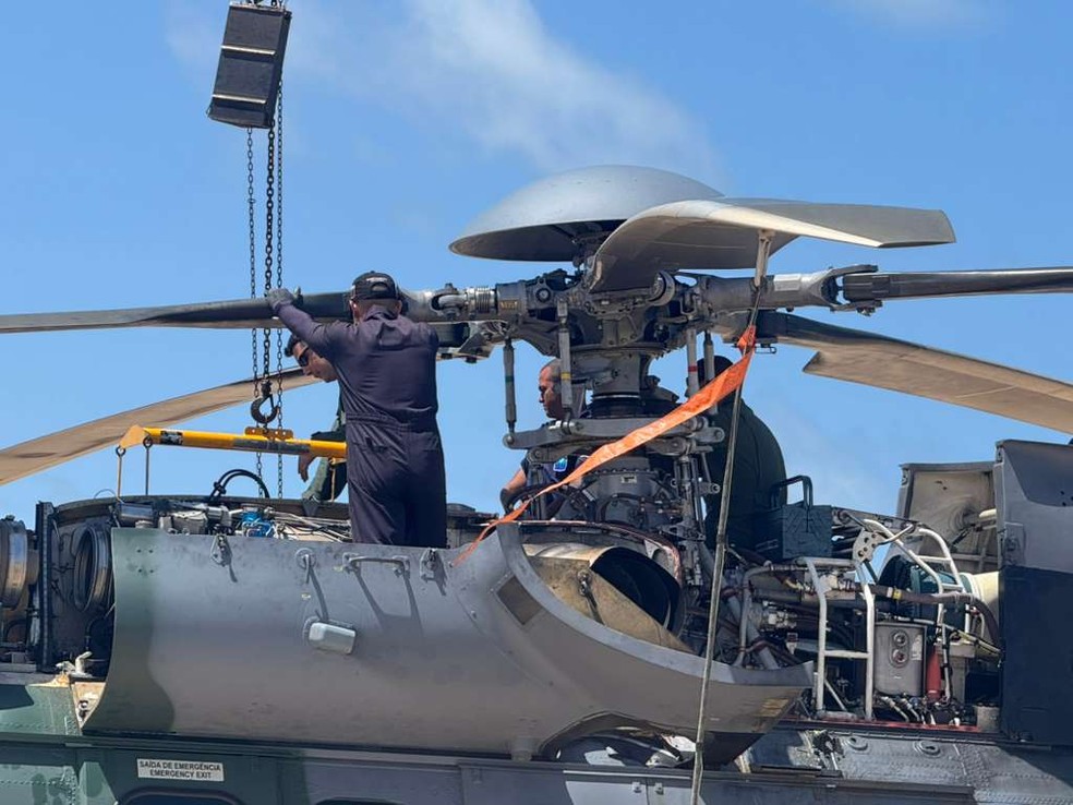 Equipes trabalhavam na manutenção do helicóptero na praia de Barra do Rio — Foto: Sérgio Henrique Santos/Inter TV Cabugi
