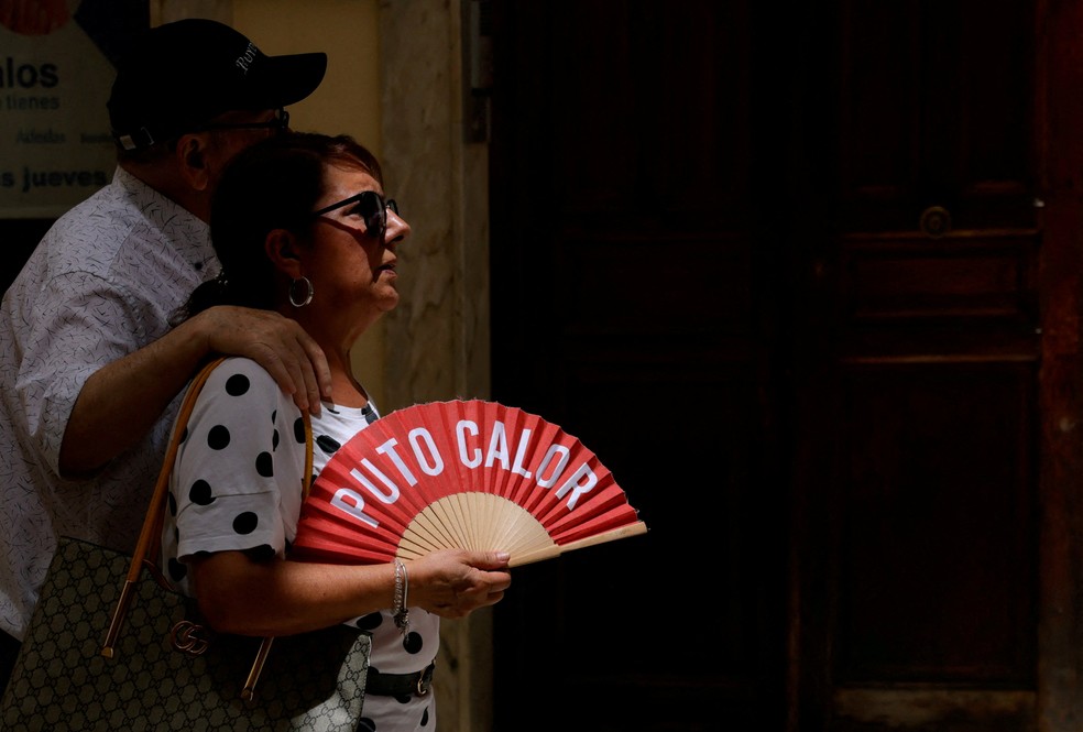 Mulher se refresca com um leque enquanto caminha pelas ruas de Ronda, na Espanha, um dia antes do início da onda de calor prevista pela agência meteorológica do país. — Foto: REUTERS/Jon Nazca