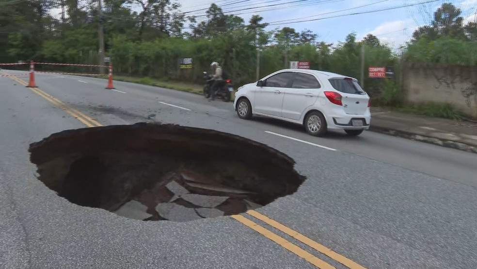Cratera do tamanho de um carro chama atenção no bairro Belvedere, em BH — Foto: Reprodução/TV Globo