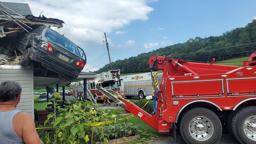 Carro de resgate tenta retirar veículo preso no segundo andar de uma casa na Pensilvânia, nos EUA — Foto: Reprodução/JUNCTION FIRE COMPANY