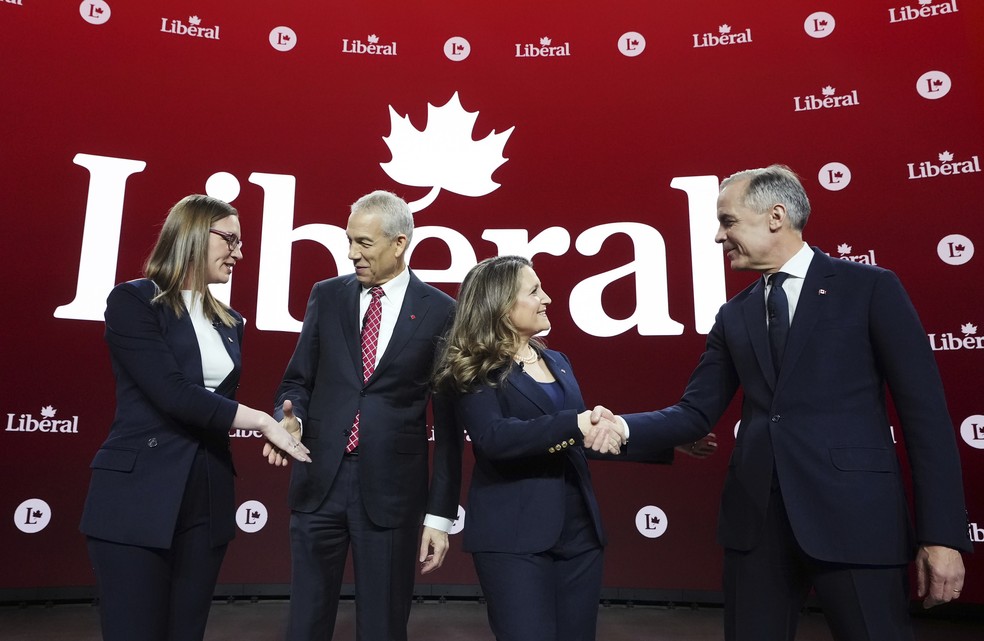 Candidatos à liderança do Partido Liberal do Canadá, Karina Gould, Frank Baylis, Chrystia Freeland e Mark Carney, se cumprimentam antes do debate em Montreal, 25 de fevereiro de 2025. — Foto: Christinne Muschi/The Canadian Press via AP