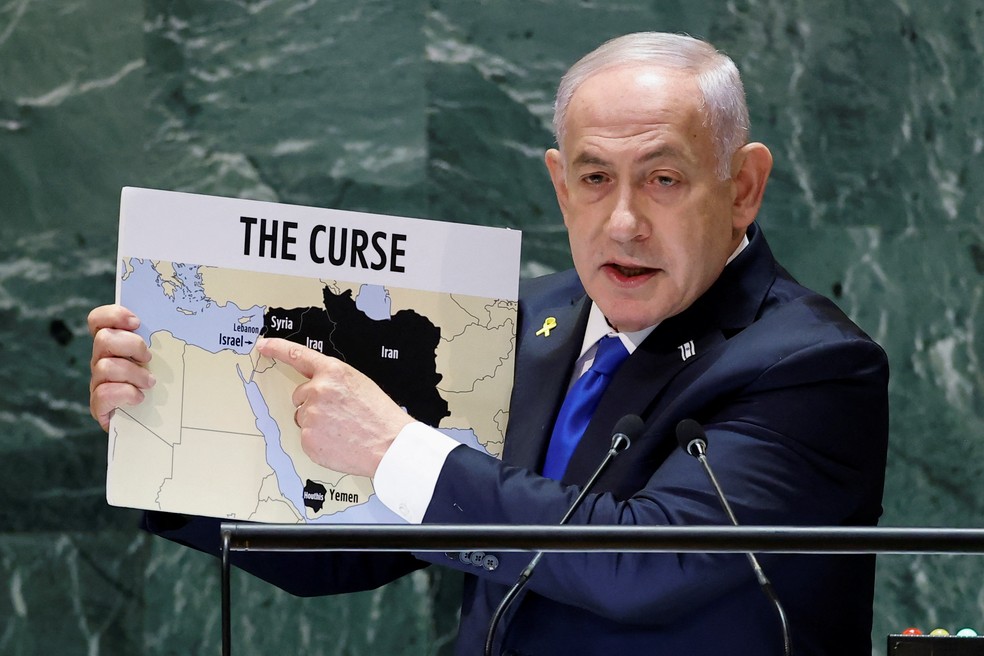 O primeiro-ministro de Israel, Benjamin Netanyahu, mostra um mapa do Irã e aliados com a inscrição "a maldição" durante discurso na Assembleia Geral da ONU, em 27 de setembro de 2024. — Foto: Eduardo Munoz/ Reuters