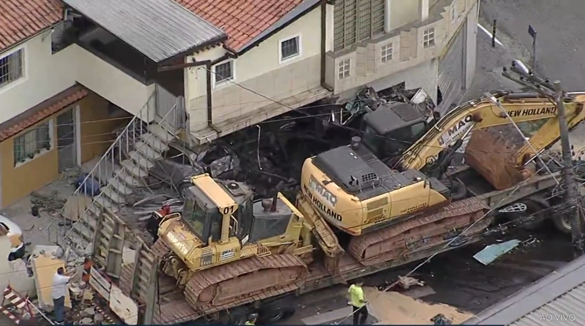 Carreta que levava tratores perde freio, bate e destrói muro de casa em Caieiras; dois ficam feridos