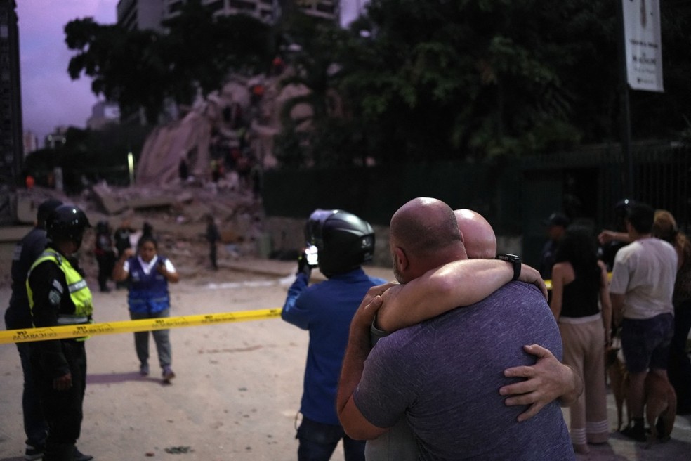 Homens reagem em frente a um pr&eacute;dio desabado ap&oacute;s um terremoto em Caracas, em 24 de junho de 2026 &mdash; Foto: Juan Barreto/AFP