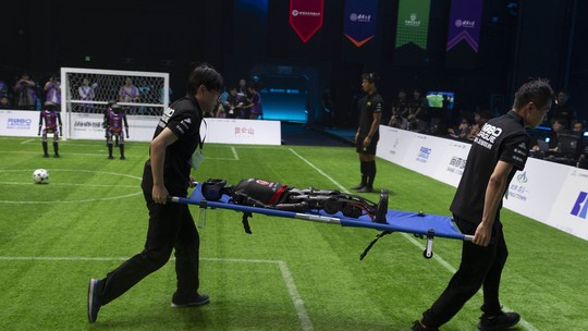 China faz primeiro campeonato de futebol entre robôs humanoides; veja VÍDEO - Partida aconteceu neste sábado em Pequim. Alguns robôs caíram durante o jogo e foram retirados do campo em macas.