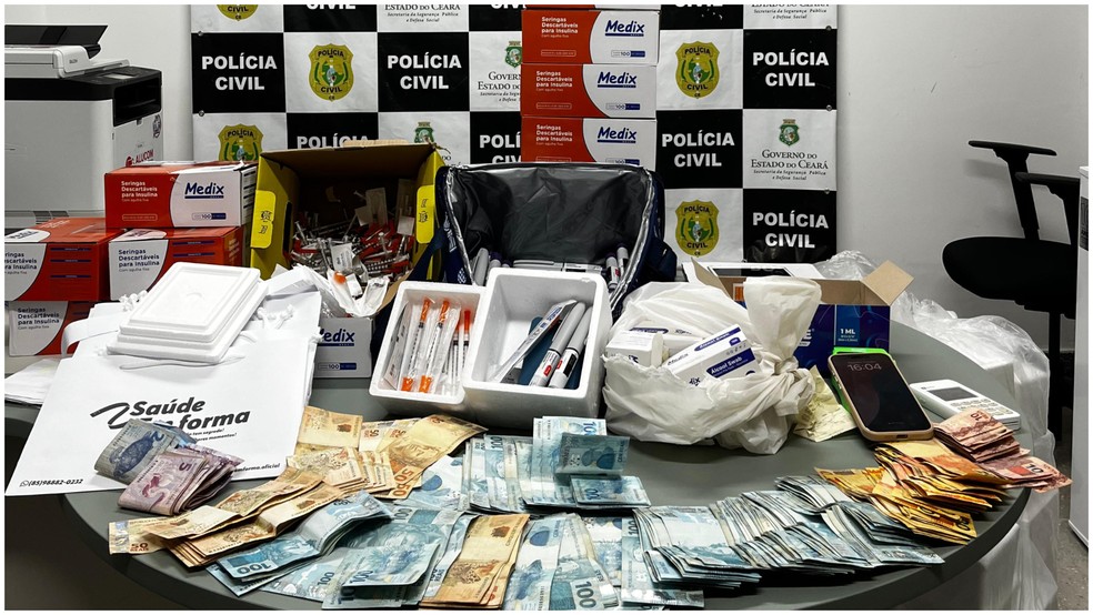 Polícia apreendeu dinheiro, cancanetas de emagrecimento cheias, seringas com doses e apetrechos na casa da suspeita — Foto: Polícia Civil