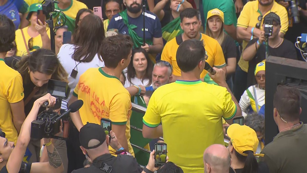 Senador Flávio Bolsonaro ao lado do deputado federal Nikolas Ferreira durante discurso no ato deste domingo (1º) em São Paulo — Foto: TV Globo