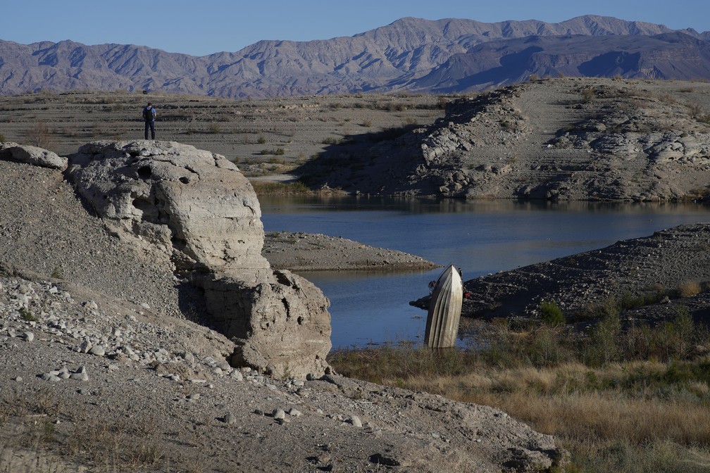 Homem observa barco até que estava submerso no Lago Mead, reservatório nos estados de Arizona e Nevada (EUA) que fornece água potável para 20 milhões de pessoas. — Foto: AP Photo/John Locher, Arquivo