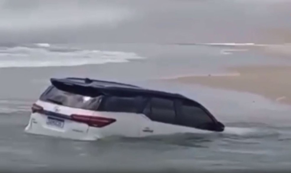 Carro de luxo fica preso na areia ao tentar atravessar praia durante maré cheia, no Ceará. — Foto: Reprodução