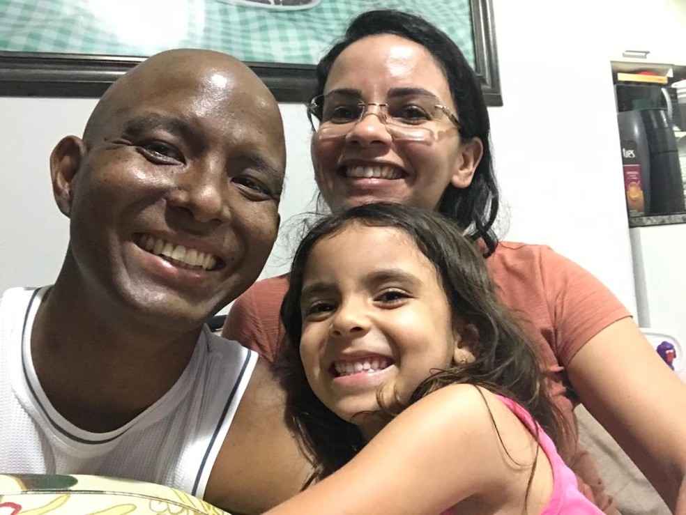 Tratamento era agressivo e provocou diversas mudanças físicas em Ricardo Nakano; na foto, ele recebe carinho da esposa e da filha — Foto: Arquivo pessoal