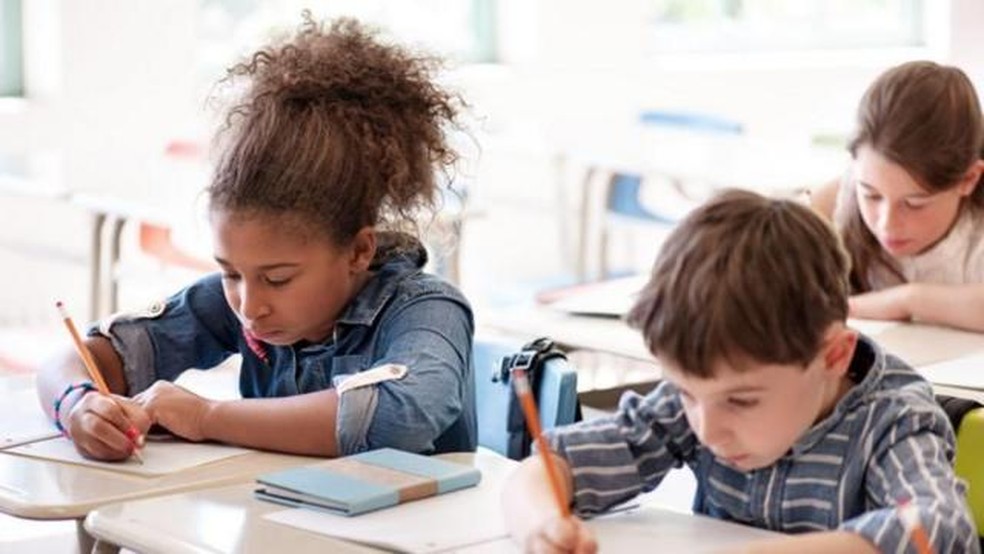 Especialistas defendem que o ditado é uma prática pouco eficaz para o ensino da ortografia. Na imagem, alunos fazem atividade na escola. — Foto: Getty Images (via BBC)