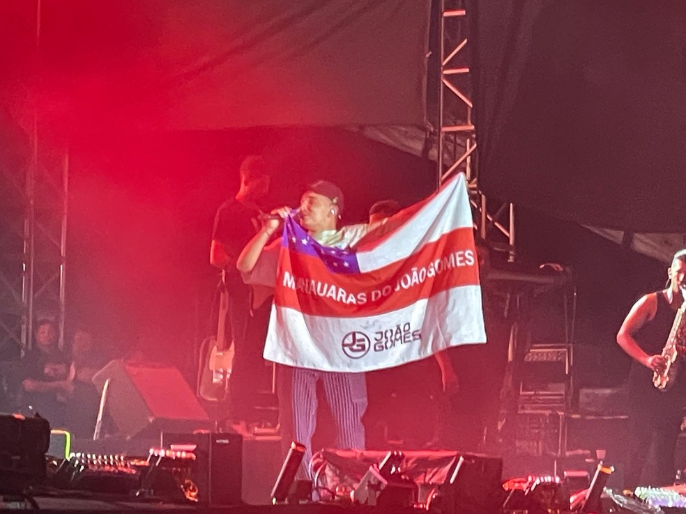 João Gomes exibe bandeira de fã-clube amazonense no palco do Manaus Passo a Paço 2024 — Foto: Sabrina Rocha/g1 AM