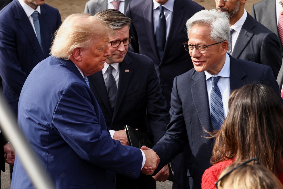 O presidente dos EUA, Donald Trump, aperta a mão do presidente e CEO da Nvidia, Jensen Huang, enquanto o presidente da Câmara dos Representantes dos EUA, Mike Johnson, republicano da Louisiana, observan. — Foto: Kevin Lamarque / Reuters