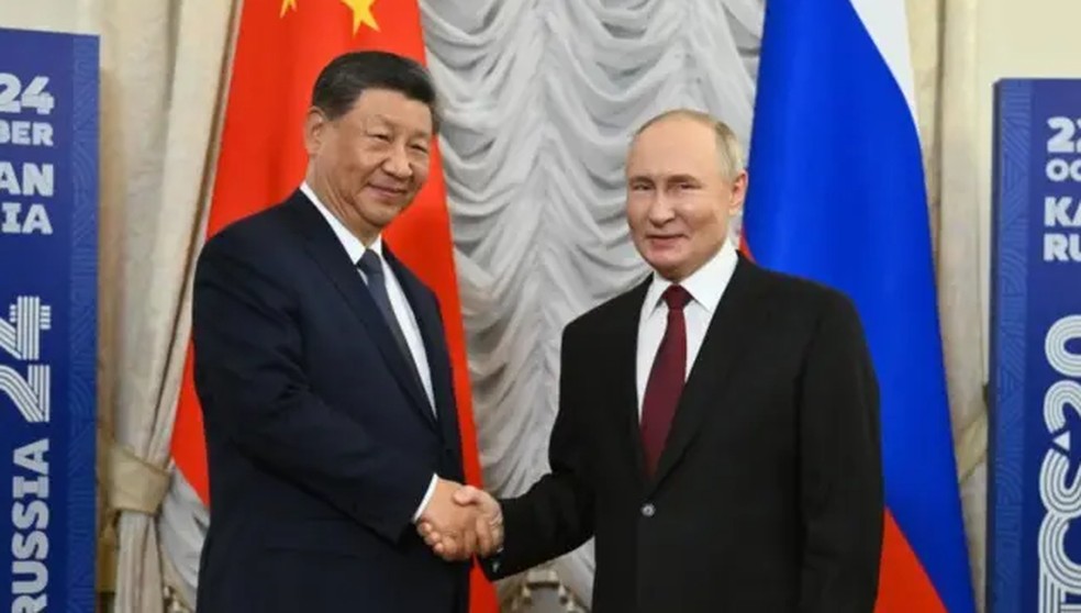 Vladimir Putin e Xi Jinping durante cúpula em Kazan — Foto: Getty Images via BBC