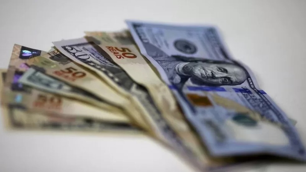 Notas de real e dólar — Foto: Reuters via BBC
